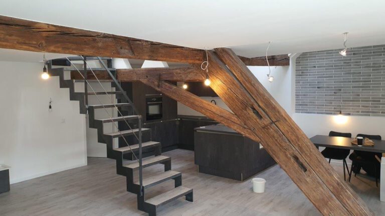 Komplettsanierte Dachwohnung mit offener Küche, Treppe, Holzträgern und Essbereich