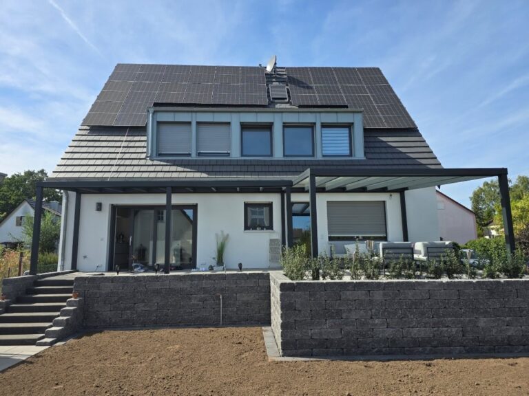 Saniertes Einfamilienhaus in Buckenhof mit modernen Solarpaneelen und Terrassenüberdachung.