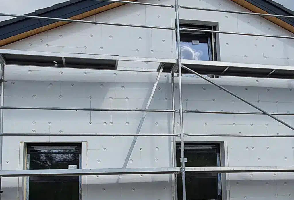 Gebäude mit Dämmplatten und Baugerüst für energetische Sanierung